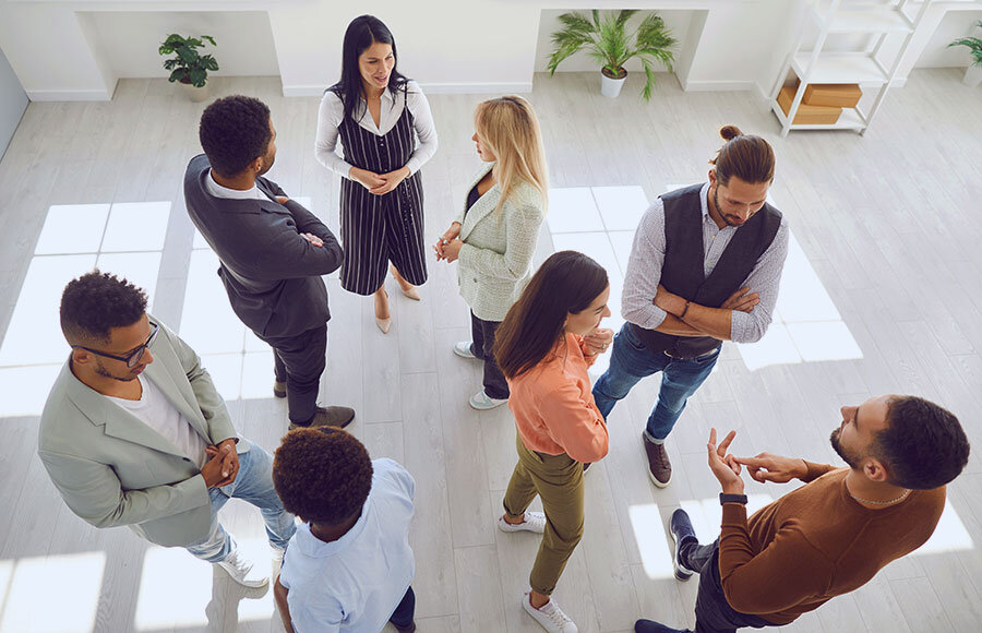 Groups of multi ethnic people standing in office and talking